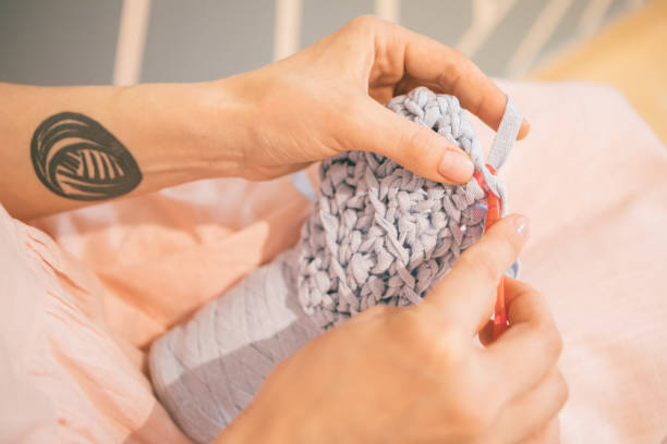 istock Cozy handmade knitting crochet process. Woman hands holding tools. 949470578