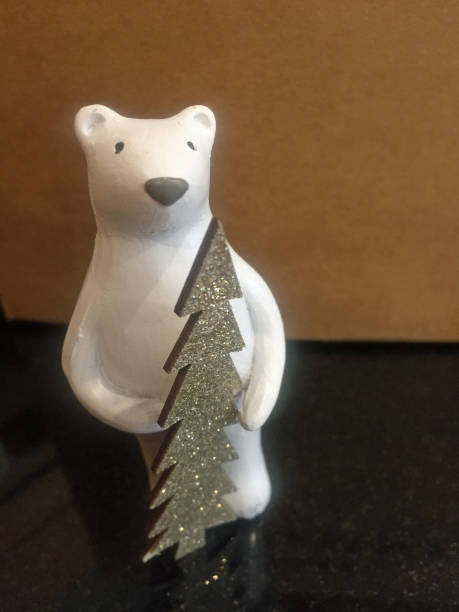 istock polar bear holding glittery tree Christmas decoration 949470978
