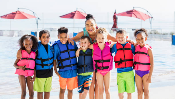 multiethniques enfants, enseignants, portant des gilets de sauvetage - animateur de colonie de vacances photos et images de collection