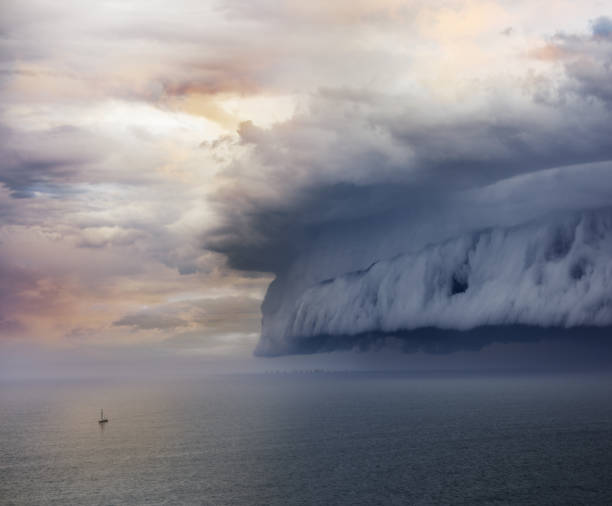 крошечная парусная лодка и входящий шторм - sea storm стоковые фото и изображения