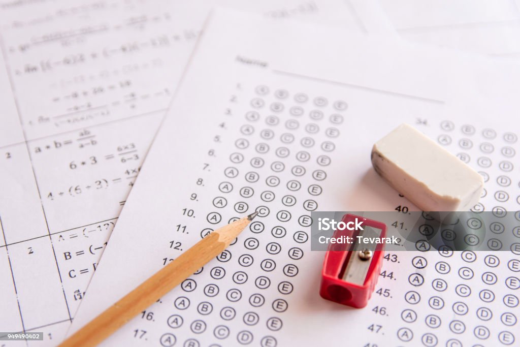 Pencil, Sharpener and eraser on answer sheets or Standardized test form with answers bubbled. multiple choice answer sheet Educational Exam Stock Photo