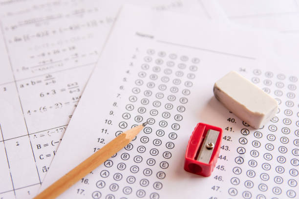 Pencil, Sharpener and eraser on answer sheets or Standardized test form with answers bubbled. multiple choice answer sheet stock photo