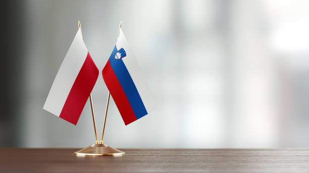 istock Polish And Slovenian Flag Pair On A Desk Over Defocused Background 949499774