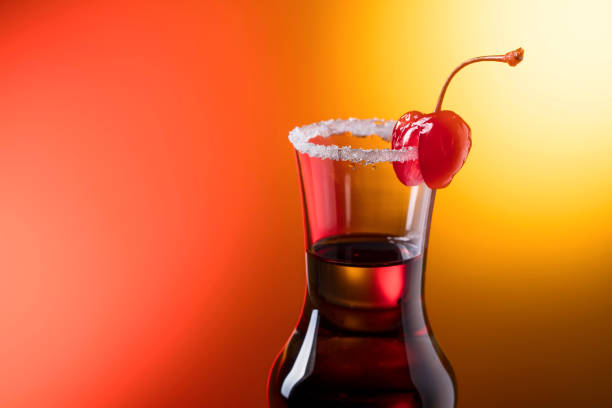 Alcohol layered shot cocktail garnished with cherry and sugar. Copy space for your text.