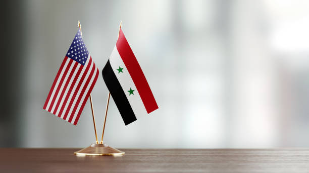 istock American And Syrian Flag Pair On A Desk Over Defocused Background 949504362