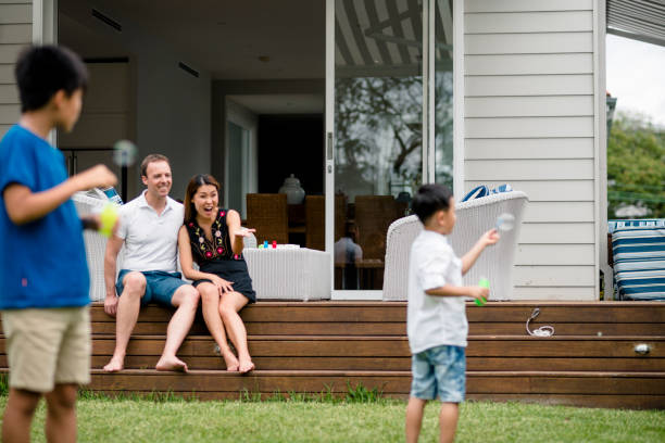 istock Young family blowing bubbles at home outside 949508128