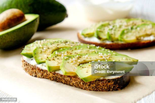 Vegan Sandwich Rye Bread Toast Avocado Slices Vegenaise Sauce Raw Arugula Toasted Sourdough Eggless Mayonnaise Wooden Table Whole Halved National Avocado Day Concept Close Up Background Stock Photo - Download Image Now