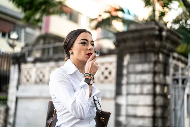 Photo of Businesswoman walking and smoking