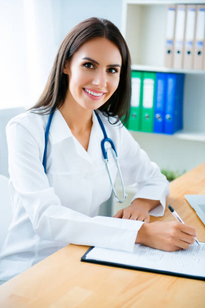 istock Happy female doctor writing conclusion for her patient 949537314