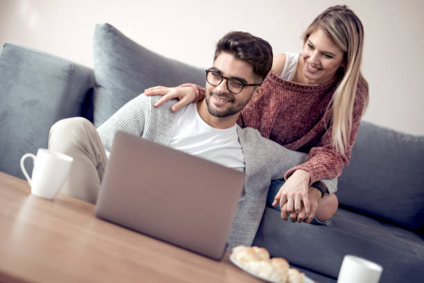 istock Young couple using laptop at home 949539028