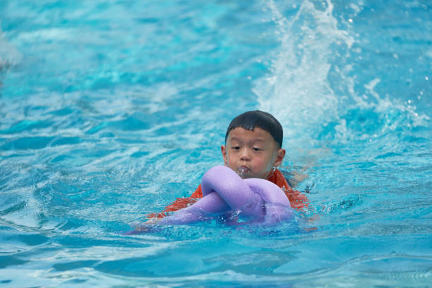istock Boy practice swimming with noodle foam floater 949552348