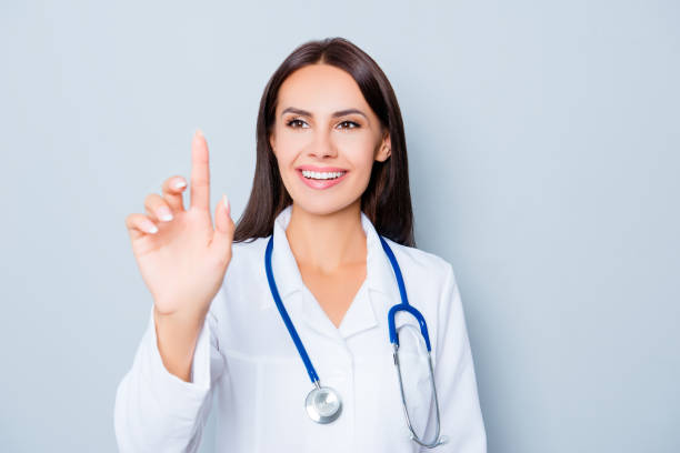 istock Young happy female doctor touching virtual screen 949557006
