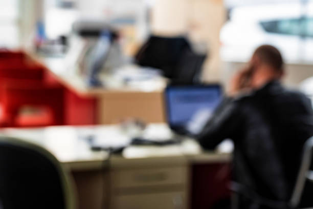 istock Blurred office interior with man speaking on phone 949560566