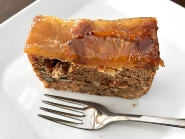 istock Pineapple and Carrot Cake Slice served with fork at cafe shop 949560854