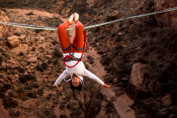 istock Female Extreme Athlete Highlining or Slacklining Hanging Upside Down 949565984