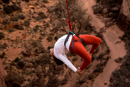 Female Extreme Athlete Highlining or Slacklining near Moab Utah over a deep canyon