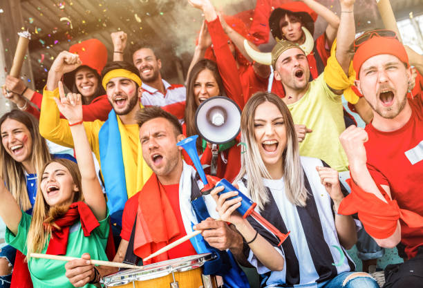 football supporters fans amis acclamations et regarder football match au stade intenational - groupe de jeunes avec des t-shirts multicolores ayant excité amusant sur le concept de championnat du monde sportif - fan hooligan screaming shouting photos et images de collection