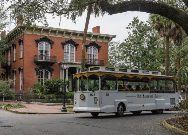 Mercer House, Savannah, Georgia People riding in a tour trolley past the famous Mercer House, a historic building that was featured in Clint Eastwood’s film ‘Midnight in the Garden of Good and Evil’. trolley bus stock pictures, royalty-free photos & images