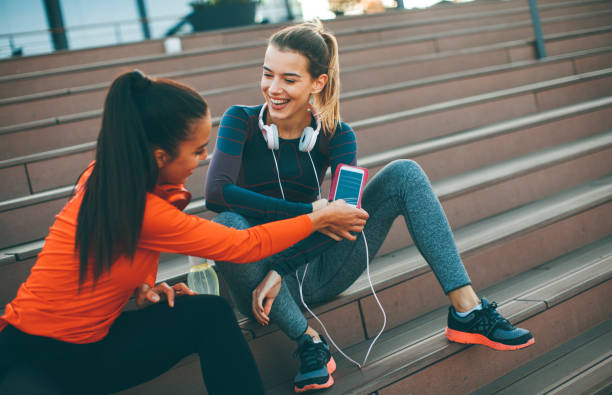 istock Two attractive female runner taking break after jogging outdoors 949573104