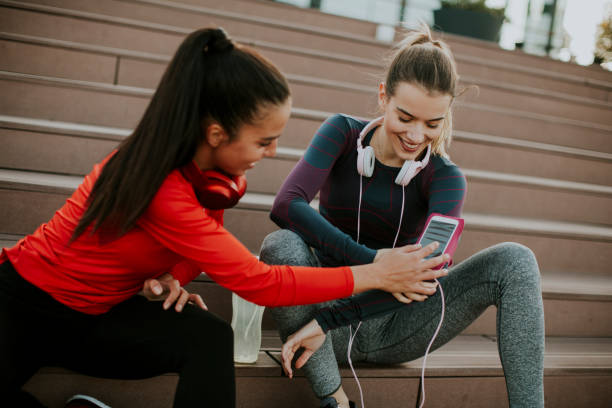 istock Two attractive female runner taking break after jogging outdoors 949573132