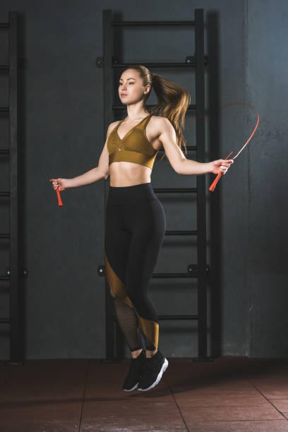 istock Young sportswoman doing jump rope workout  in gym 949580714
