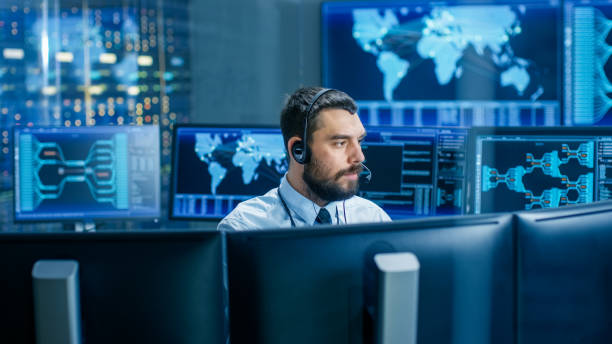 istock System Control Room Dispatcher Talks into Headset. He Controls Correct Work of the Facility. In the Background Multiple Monitors Show Technical Data. 949580990