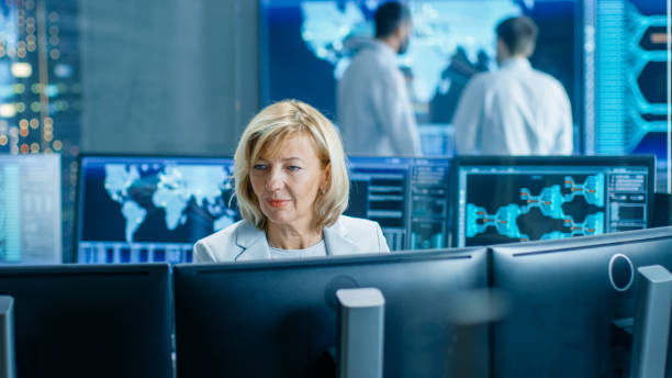 istock System Monitoring Room Professional Female Operator Observes Correct Functioning of the Facility. In the Background People Working with Interactive Map. 949581014