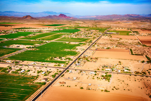 Fields of crops in a valley in the desert climate of Arizona just outside of Phoenix as shot from an altitude of about 1000 feet from a helicopter.