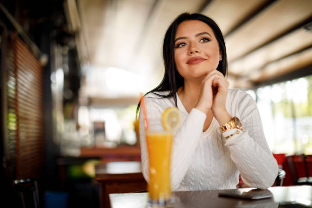 istock Young attractive woman drinking fresh orange juice 949589896