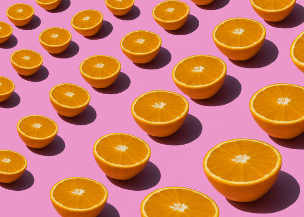istock Colorful fruit pattern of fresh orange slices on pink background 949598610