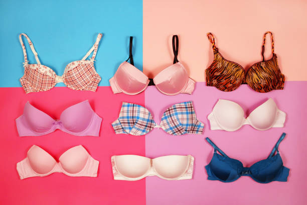 Set of different bras on multicolored background stock photo