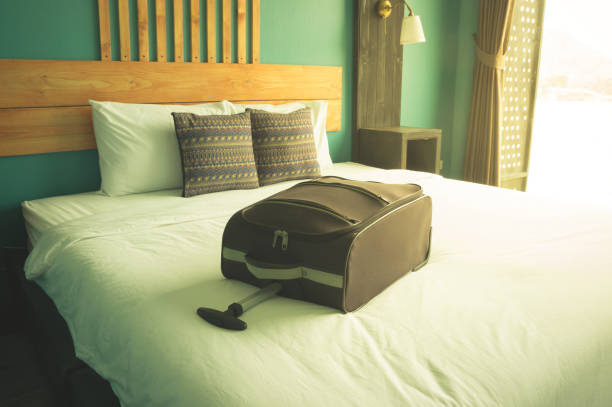 istock Suitcase on bed in hotel room. 949600100