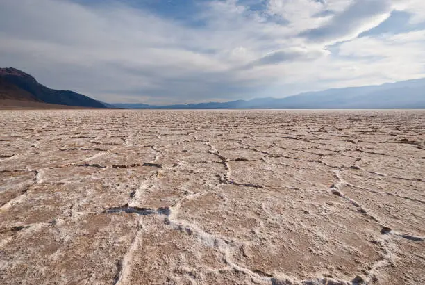 Badwater Basin is the lowest point in North America at 282 feet below sea level. Periodic rainstorms flood the valley floor but soon evaporate because of the intense heat, leaving behind a pattern of crystals on the salt pan. Average annual rainfall in Badwater Basin is 1.9 inches a year. According to legend, Badwater gets its name from a mule that refused to drink the salty water. Badwater Basin is in Death Valley National Park, California, USA.