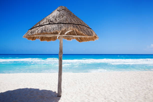 istock Straw grass shade umbrella on seaside 949611484