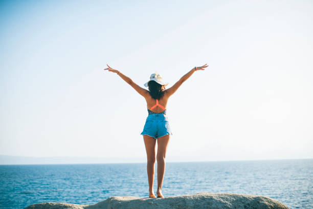 istock Pretty young woman on the stony shore 949611496