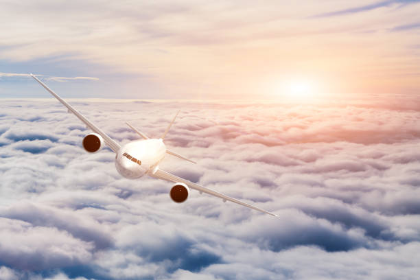 istock Airplane flying above the clouds at sunset. Reflection on aircraft 949615354