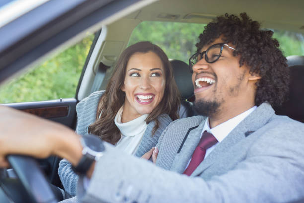 istock Happy young couple driving in a car while smiling 949615914
