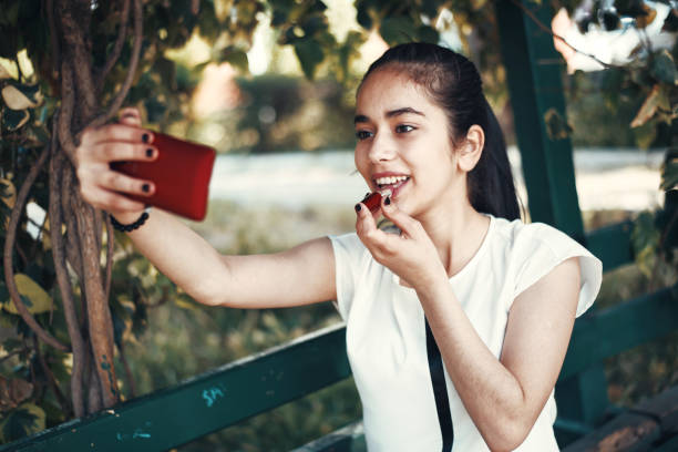 istock Teenage Girls using Smartphone as Vanity Mirror 949619450