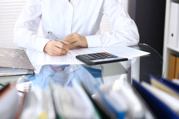 istock Female bookkeeper or financial inspector  making report, calculating or checking balance. Internal Revenue Service checking financial document. Audit concept in busines 949619784