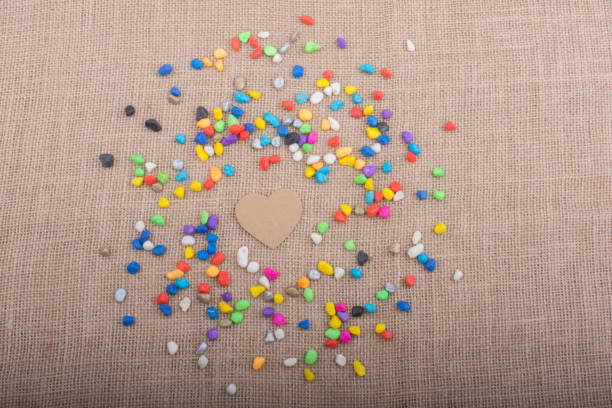 istock Paper heart amid pebbles on canvas ground 949626698