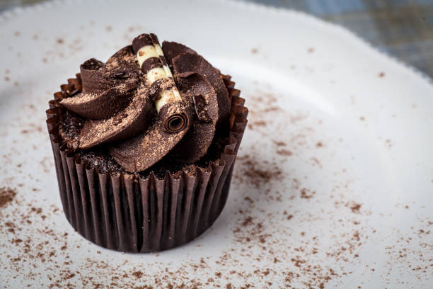 istock Chocolate cupcake on white plate, dusted with cocoa powder 949627198