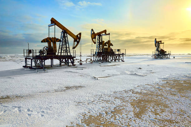 istock oil pump, snow winter, yellow sunset, blue sky 949635572