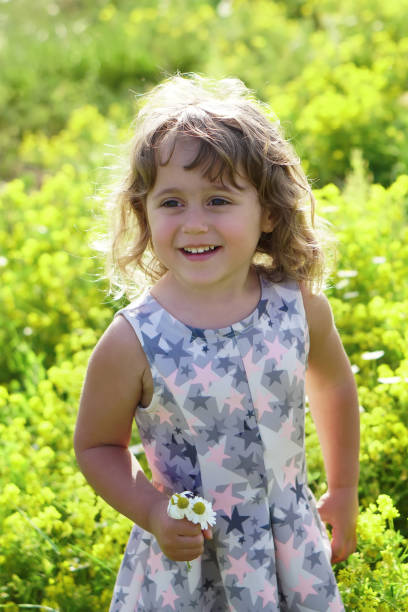 istock little girl in on a flower field 949636242