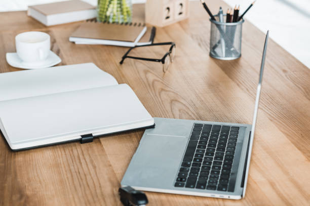 istock Laptop and notebook on wooden table in office 949640940