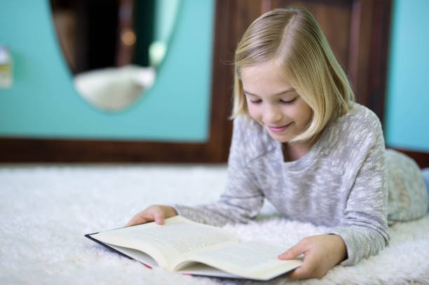 istock A blonde elementary age girl reads in her bedroom 949652312