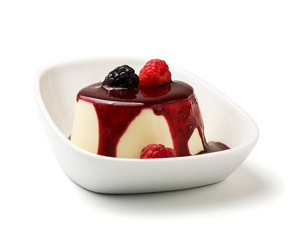 Panna cotta with berry fruit sauce in a white isolated bowl