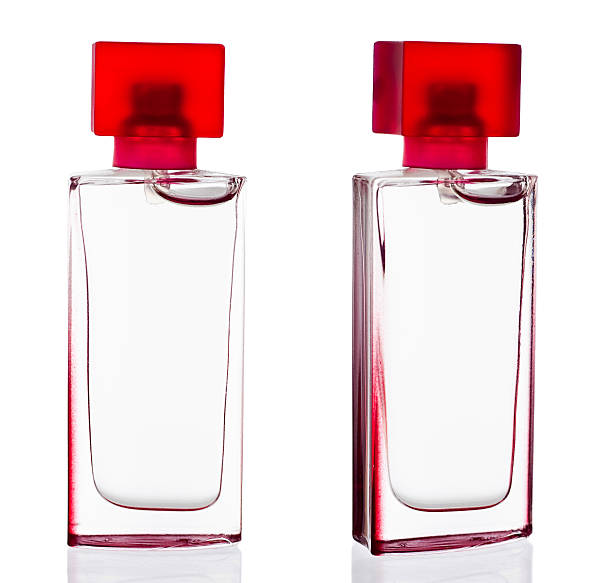 Deux bouteilles de parfum clair avec couvercle rouge - Photo