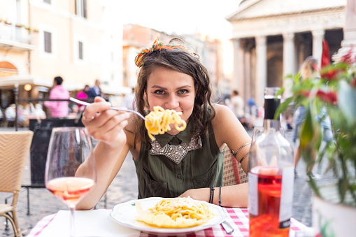 Young beautiful woman having meal in front ot  Pantheon in Rome