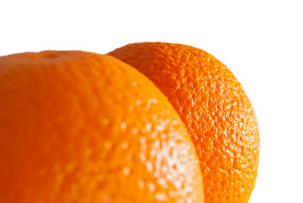 istock bright colored sides of two oranges on white background 949697116