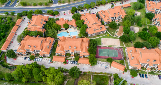 Orange townhomes high above entire apartment complex view Aerial drone view Orange townhomes high above entire apartment complex view - Austin , Texas , USA - with tennis court , swimming pool retirement community stock pictures, royalty-free photos & images